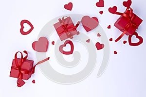 Valentine`s day background.On a white background red hearts made of paper Â  and red boxes with a gift.